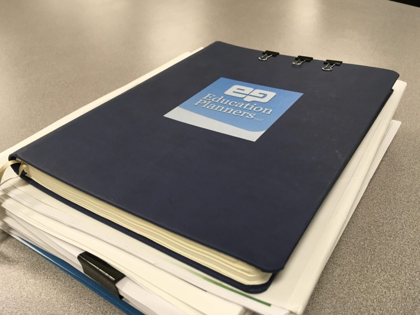 Two stacked notebooks with a blue cover on top.